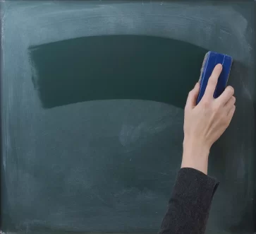 Teacher cleaning the chalkboard, suits horizontal composition